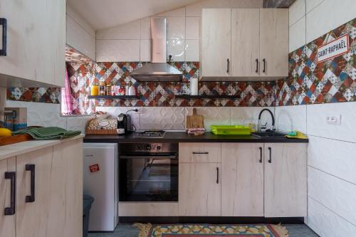 a kitchen with wooden cabinets and a stove top oven at Brvnara Iverak in Mokra Gora