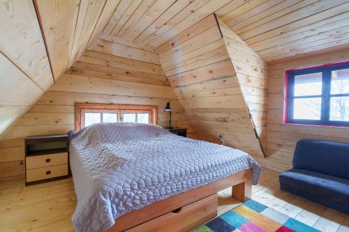 um quarto num chalé de madeira com uma cama e um sofá em Brvnara Iverak em Mokra Gora