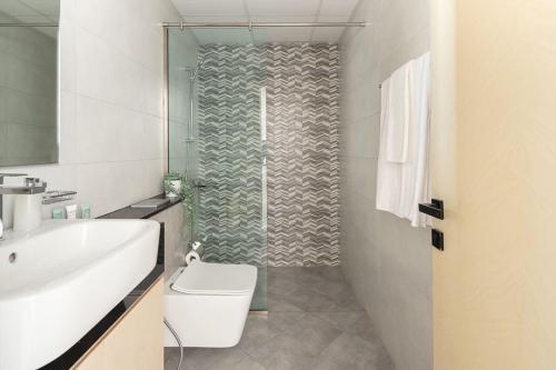 y baño con ducha, aseo y lavamanos. en Frank Porter - Binghatti Avenue, en Dubái