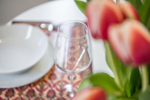 a wine glass sitting on top of a table with flowers at Suite649 Nuova 5 in Modena