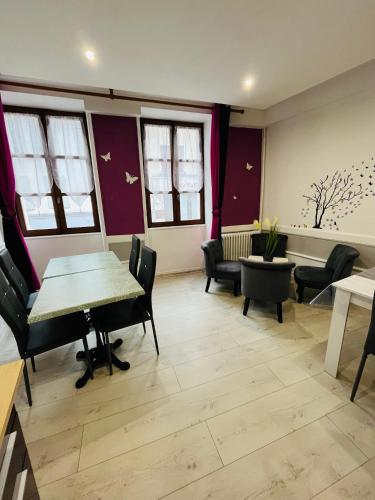a waiting room with chairs and a table and windows at Ludotel in Belley