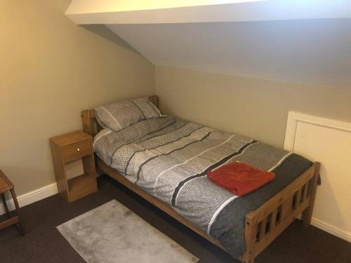 een slaapkamer met een bed en een nachtkastje bij North Wales family homes, zip world, Snowdonia, beach retreats in Blaenau-Ffestiniog