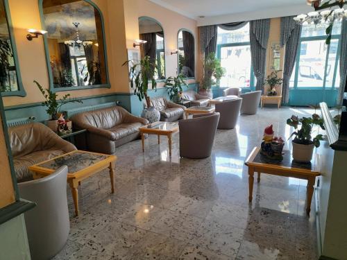 eine Lobby mit Sofas, Tischen und Fenstern in der Unterkunft Hotel Le Dome in Brüssel