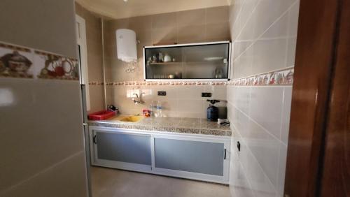 a small kitchen with a sink and a mirror at Appartement centre de Taghazout 2 -WiFi in Taghazout