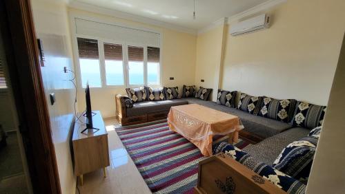 a living room with a couch and a table at Appartement centre de Taghazout 2 -WiFi in Taghazout