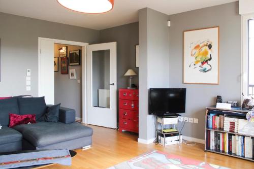 - un salon avec un canapé et une télévision dans l'établissement Cozy family nest with a beautiful terrace, à Paris