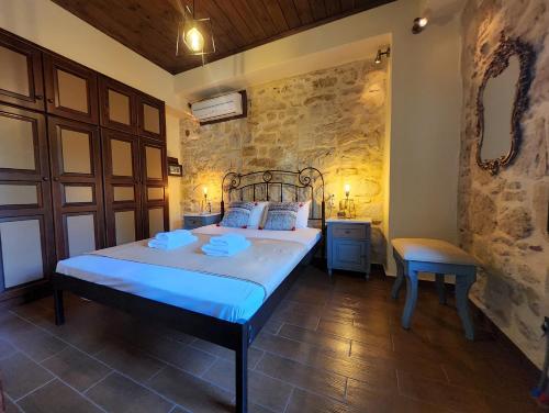 a bedroom with a bed and a stone wall at Villa Ydramia Seaview in Dhrámia