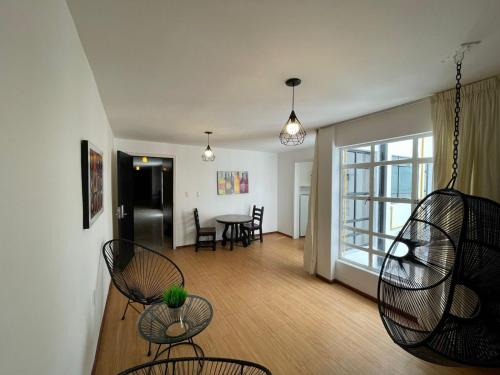 a living room with chairs and a table with a window at Suites Havre in Mexico City