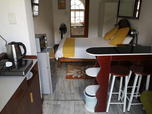 1 dormitorio con 1 cama y cocina con mesa en Lotus Guest House, en Johannesburgo