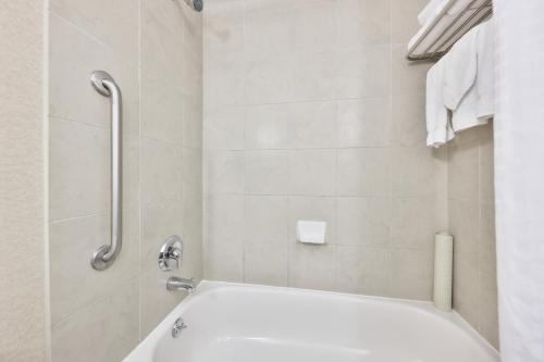 a white bathroom with a tub and a shower at Admiral Inn Mississauga in Mississauga