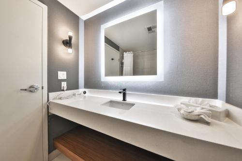 a bathroom with a sink and a mirror at Admiral Inn Mississauga in Mississauga