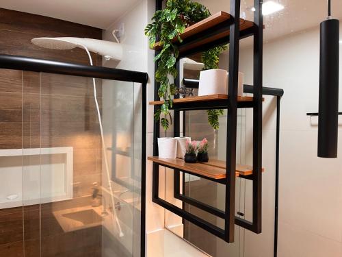 a bathroom with a shelf with plants on it at Loft Calmo ao lado do Shopping in Brasilia