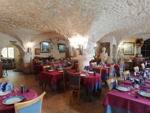 a dining room with red tables and chairs at Hostellerie Saint Martin- Logis Hôtel et Restaurant in Creully
