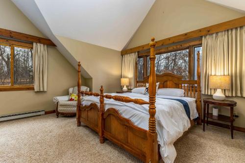 Schlafzimmer mit einem großen Holzbett und Fenstern in der Unterkunft 4 Bdrm Dog-Friendly Territory Getaway in Galena