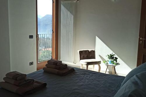 a bedroom with a bed with a chair and a window at Larius Apartment - Como Lake View in Mandello del Lario