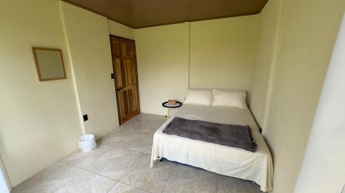 Habitación pequeña con cama y puerta en Hospedaje Kukul San Vito, en San Vito