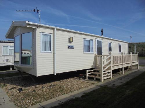 a white trailer with a porch and a house at Golden Anchor Parkstone 6 Berth, Central heated in Chapel Saint Leonards