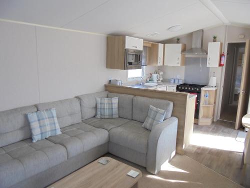 a living room with a couch and a kitchen at Golden Anchor Parkstone 6 Berth, Central heated in Chapel Saint Leonards