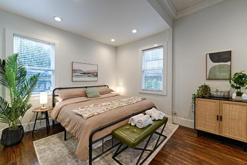 a bedroom with a large bed and two windows at Greenhouse Uptown in Dallas
