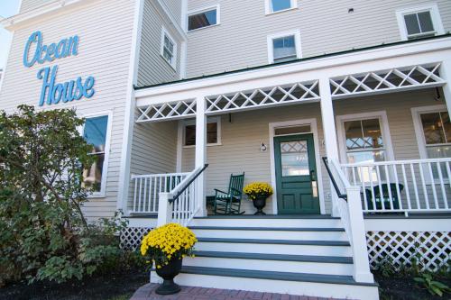 a white house with a green door and stairs at Ocean House Hotel & Motel in Old Orchard Beach