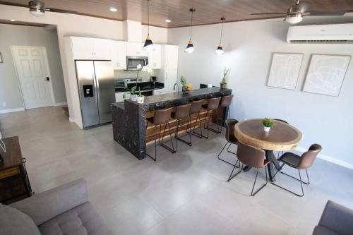 uma cozinha com um bar, uma mesa e cadeiras em Tortuga House Playa Avellanas em Playa Avellana