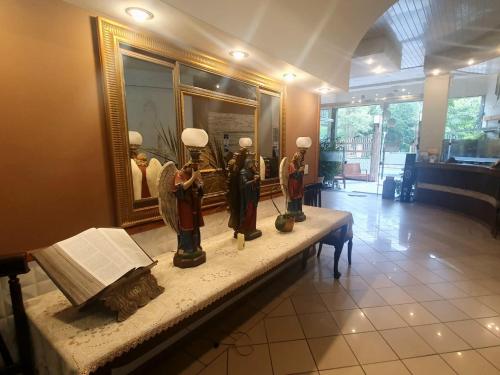 a group of statues sitting on a table in a room at Presidente Hotel in Poços de Caldas