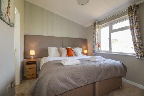 a bedroom with a large bed with two towels on it at 23 Meadow Retreat in Liskeard