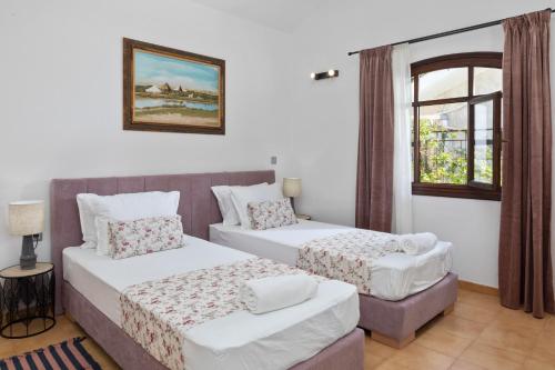 a bedroom with two beds and a window at Kalami Lookout Villa in Kalami
