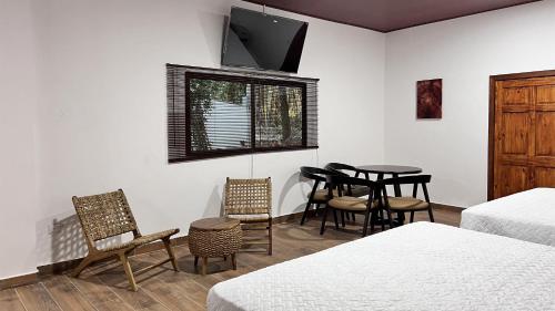 AhuachapánにあるTermales la Montaña “Suite Aire de Montaña 1”のテーブル、椅子、テレビが備わる客室です。