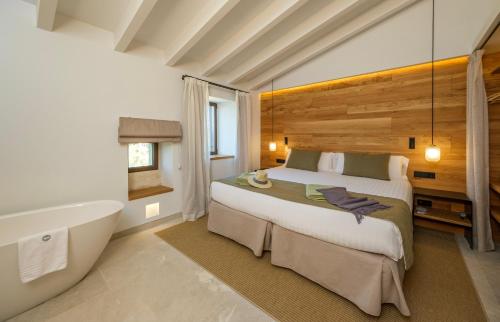 a bedroom with a bed and a bath tub at Fincahotel Treurer - Olive Grove & Grand House - Adults Only in Algaida