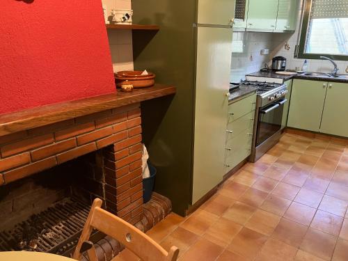 a kitchen with a brick fireplace and a red wall at Villa Yanet 