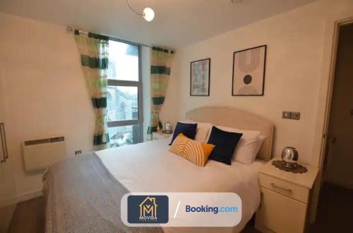 um quarto com uma cama e uma janela em Beautiful Apartment Next To LGI By Movida Property Group Short Lets & Serviced Accommodation em Leeds