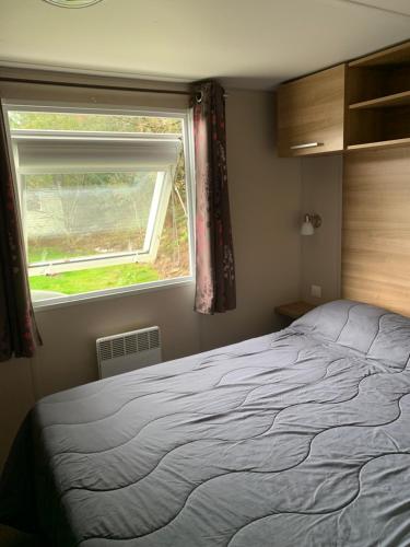 a bedroom with a bed and a window at Mobile Home Village Vacances Océan et Nature in Seignosse