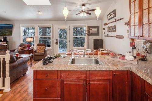 a kitchen with a sink and a living room at Community Private Beach on Whitefish Lake and About a Mile to Downtown in Whitefish