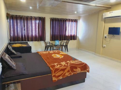a bedroom with a bed and a table and chairs at Hiral residency in Matheran