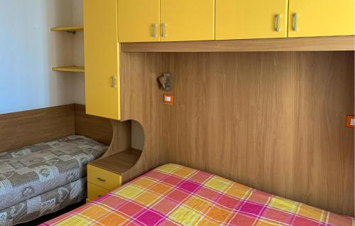 - une petite chambre avec un lit et des armoires jaunes dans l'établissement Mara 12, à Rosolina Mare