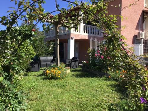 un jardín frente a una casa con flores en Appartement Vals les bains, en Vals-les-Bains