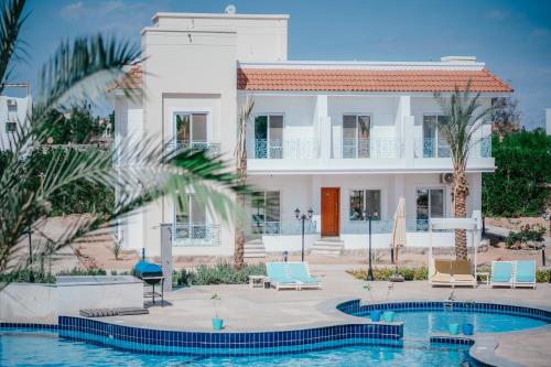 a villa with a swimming pool in front of a house at Blue Residence Dahab in Dahab