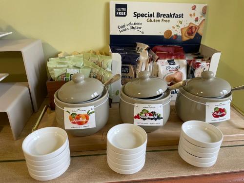 a counter with three pots and plates and some food at Relais Fontana Rosa B&B Wellness in Caprino Veronese