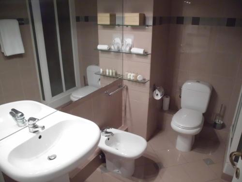a bathroom with a white sink and a toilet at Monaco Beach Balcony Apartments in Beausoleil