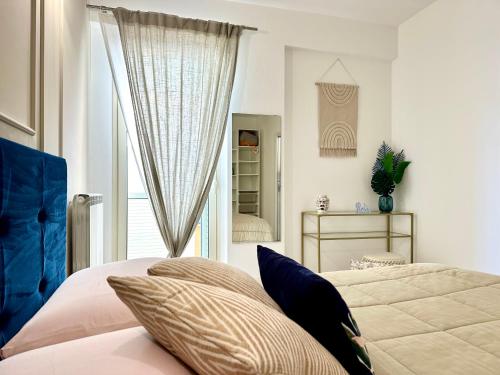 1 dormitorio con cama con almohadas y ventana en Casa Vivì, en Porto SantʼElpidio