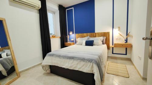 um quarto com uma cama grande e uma parede azul em Apartamento junto a Calle Larios em Málaga