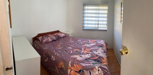 Un dormitorio con una cama con un edredón colorido y una ventana en Casona Quilacan en 