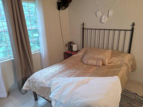 a bed with two pillows on it in a bedroom at The African Lily in Kingston