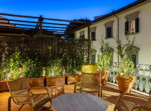 a patio with chairs and a table and a fence at This Time Tomorrow in Florence in Florence