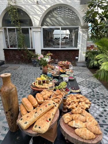 a table with a bunch of bread and pastries on it at DYORE House by Bharat Mahal Palace in Jaipur