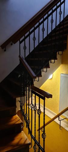 a staircase with black railings and a yellow wall at Rezidence Lipka in Králíky