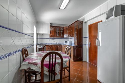 een keuken met een tafel en stoelen en een koelkast bij Best Houses 16 - Casa do Centro in Peniche