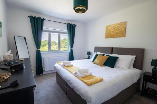 Un dormitorio con una cama grande con toallas. en The Breckland at Sugar Lane Farm, en Bollington