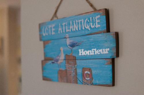 une photo d'un panneau suspendu sur un mur dans l'établissement Norman studio in city center, à Honfleur